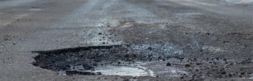 pothole in road in front of car