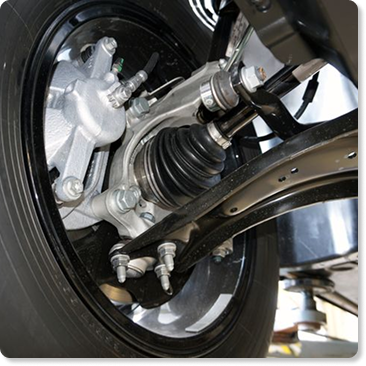 A close-up view looking under a tire with a brand-new steering suspension coil installed by SuperTech Auto